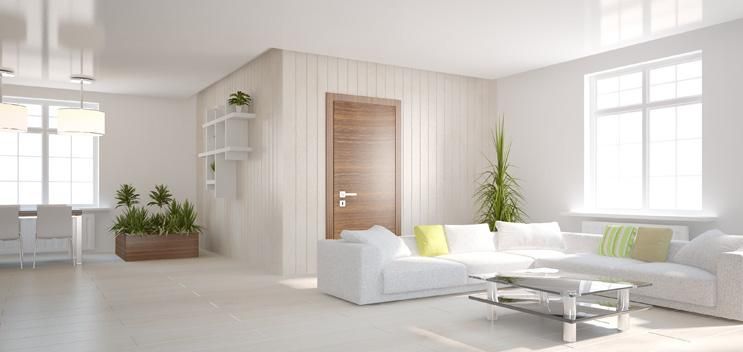 Abbildung eines hell beleuchteten Wohnzimmers mit großen lichtdurchlässigen Fenstern.